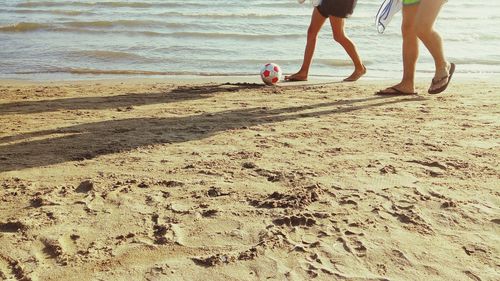 Low section of people standing on beach