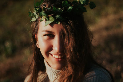 Portrait of smiling young woman against plants