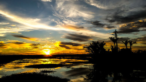 Scenic view of dramatic sky over lake during sunset