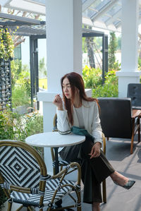 Young woman sitting on table at cafe