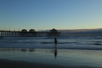 Silhouette of pier on beach