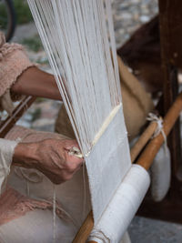 Cropped image of person working with loom in workshop