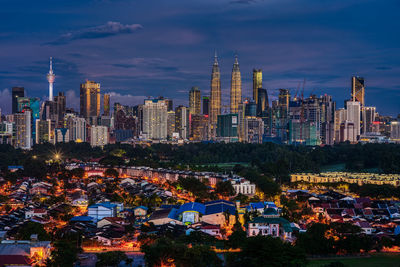 Illuminated buildings in city against sky