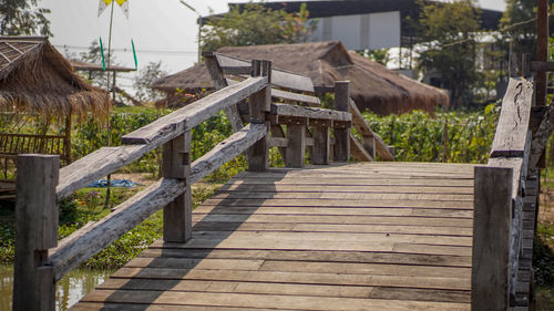 Wooden fence by footpath leading towards building