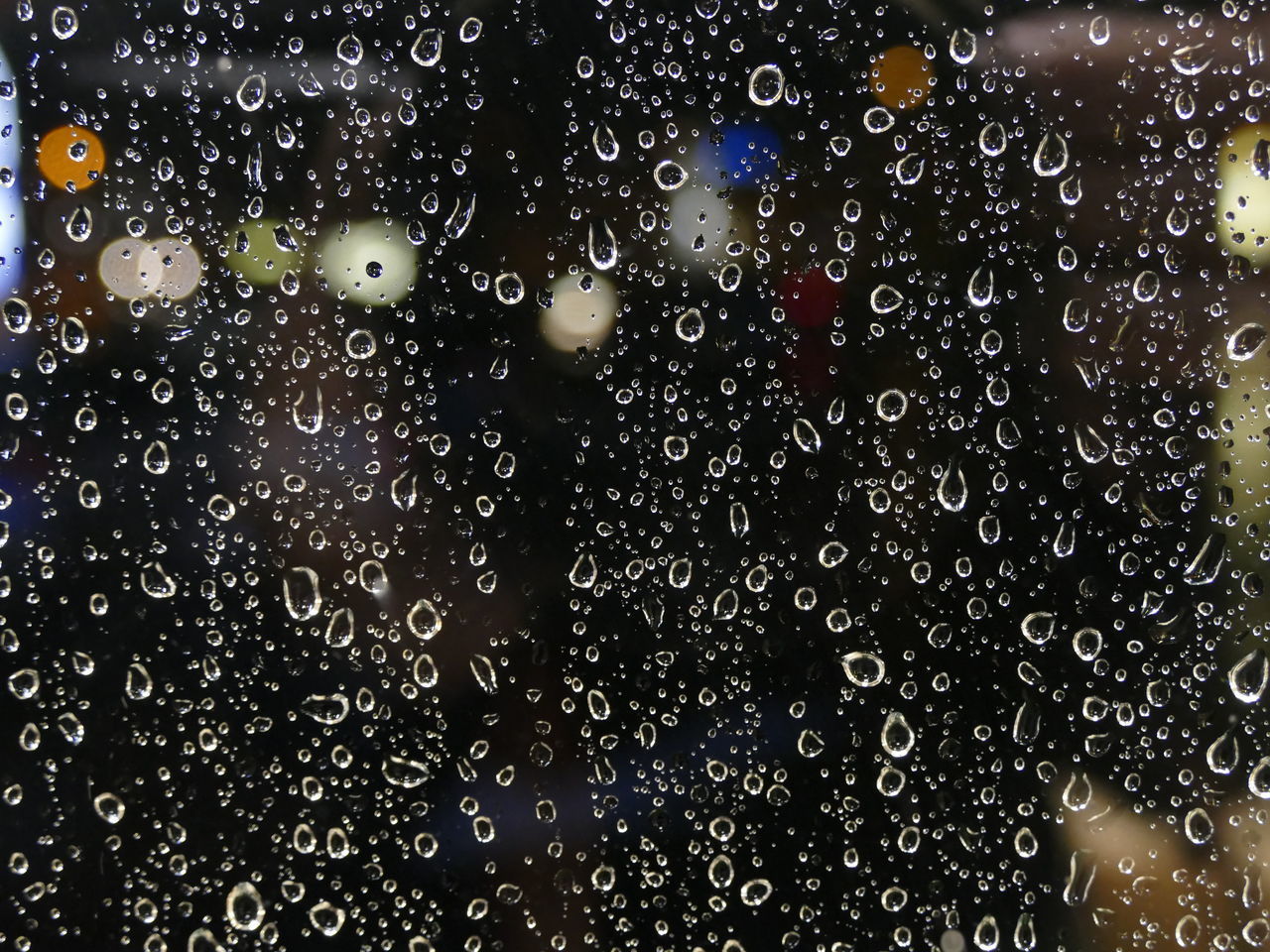 CLOSE-UP OF RAINDROPS ON GLASS WINDOW