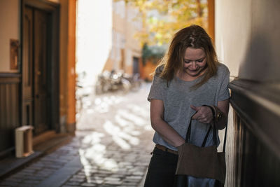 Mid adult woman searching something into purse