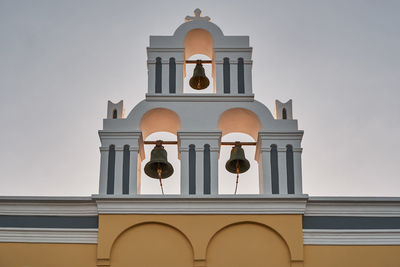 Yellow - colorful bell tower of the agios theodoros church - fira village in santorini, greece