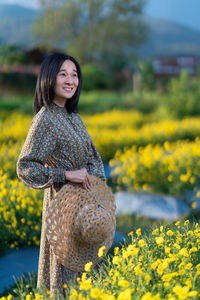 Portrait of smiling woman standing on field