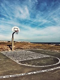 Road sign on beach against sky