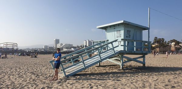 Man on beach against clear sky