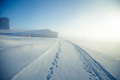 Snow covered land against sky