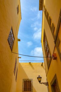 Low angle view of yellow building against sky