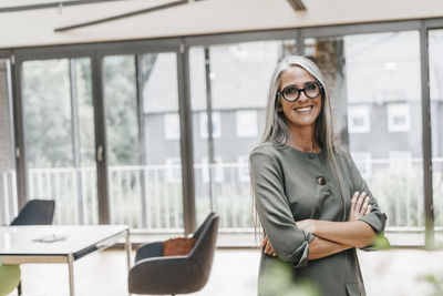 Portrait of smiling woman with long grey hair in office