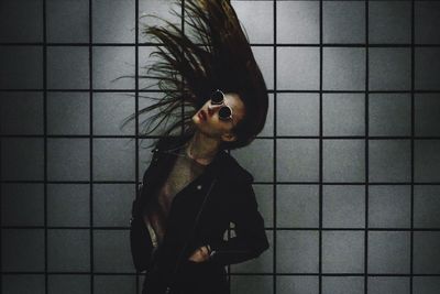 Woman tossing hair against wall