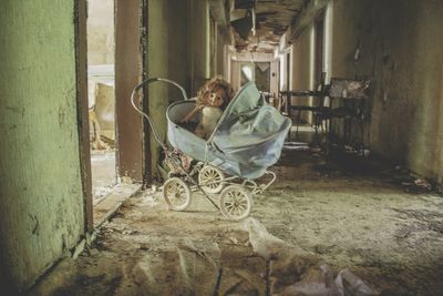 Portrait creepy doll sitting in abandoned building