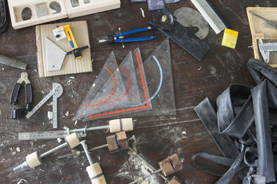 High angle view of work tools on wooden table at workshop