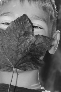 Close-up portrait of man holding leaf