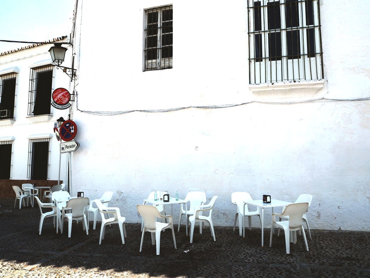 EMPTY CHAIRS AND TABLES AGAINST WALL IN HOUSE