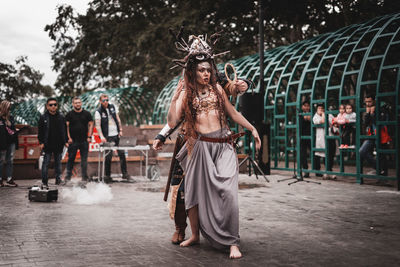 Full length portrait of young woman dancing at music concert