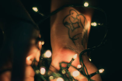 Close-up of hand holding illuminated light painting at night