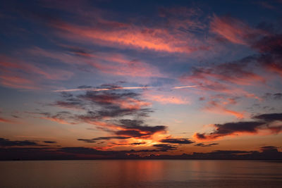 Scenic view of sea against dramatic sky during sunset