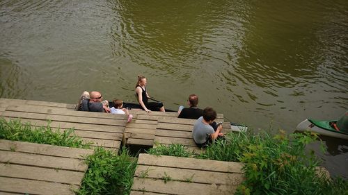 High angle view of people sitting by lake