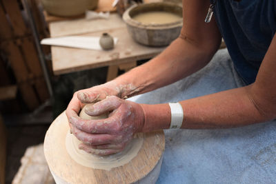 Midsection of potter working with clay