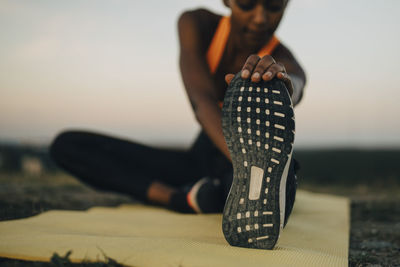 Young female athlete doing yoga during sunset