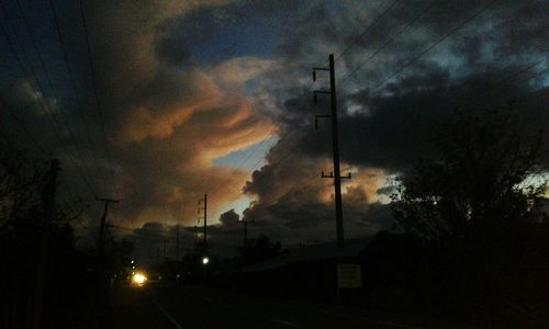 Electricity pylon against cloudy sky