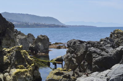 Scenic view of sea and mountains against sky