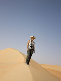 Low angle view of person standing on sand dune