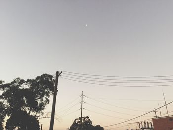 Low angle view of power cables against clear sky