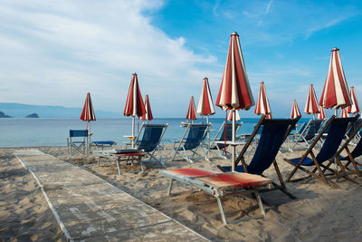 Closed canopies and sun loungers on beach
