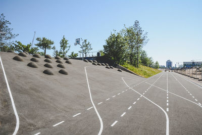 Road amidst trees against clear sky