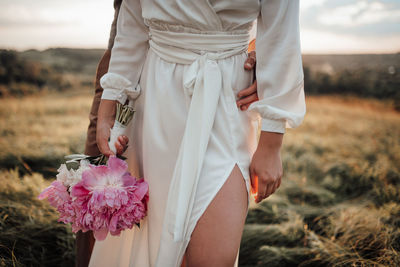 Midsection of woman standing on field