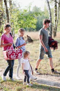 Mother with children walking in forest