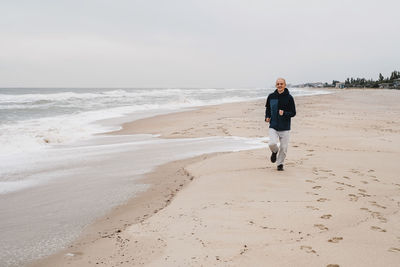 Rear view of woman walking at beach