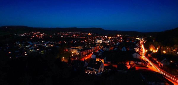 High angle view of illuminated town against sky at night