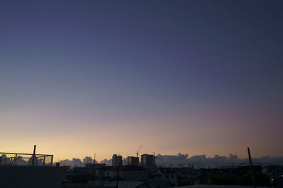 Silhouette buildings against clear sky at sunset