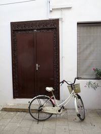 Bicycle parked against wall in city