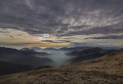 Scenic view of mountains against cloudy sky