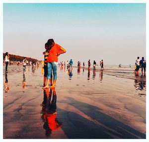 People on beach against clear sky