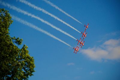 Low angle view of airplane flying against blue sky