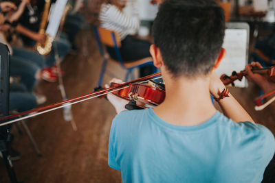 Rear view of men playing music concert