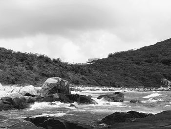 Rocks by sea against sky