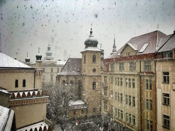 Buildings in city against sky during winter