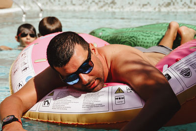 High angle view portrait of friends relaxing on swimming pool