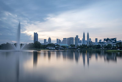 Reflection of buildings in city against sky
