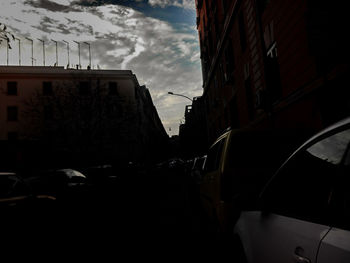 Cars on city street against sky