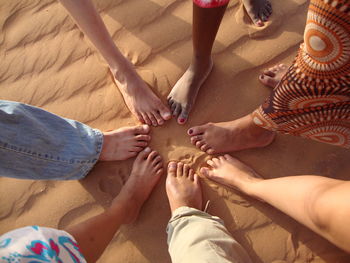High angle view of people hands on sand